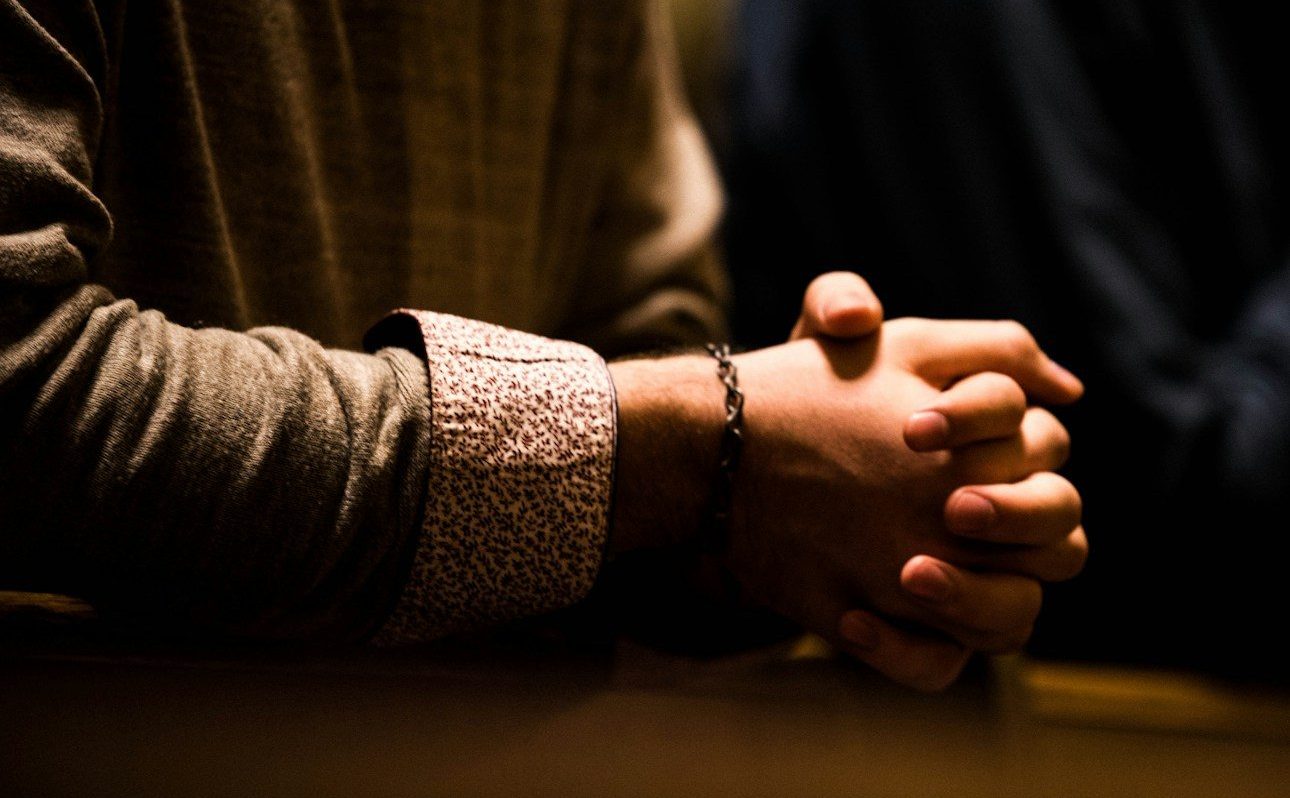 two people holding hands while sitting at a table