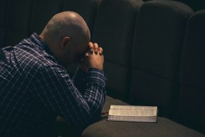 a man sitting on a couch with his hands on his face
